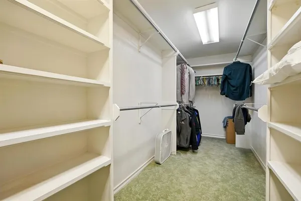 a view of walk in closet with clothes and shoes