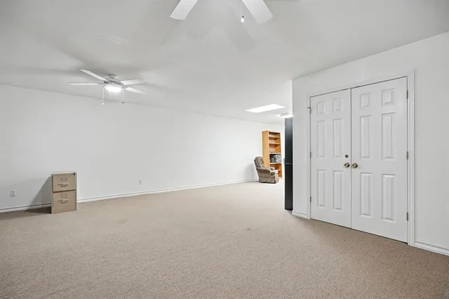 an empty room with a ceiling fan and a window