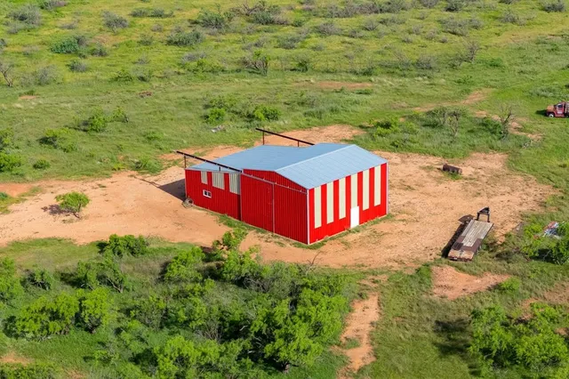 a green field with some trees in the background