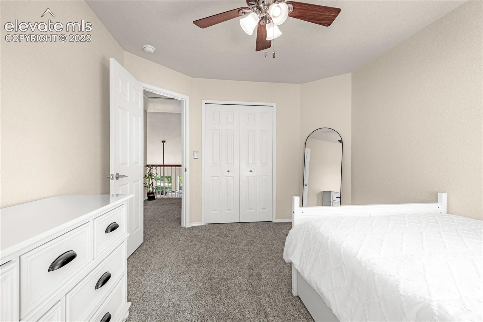 7985 Orchard Path Road Colorado Springs, CO 80919 - Photo 37 of 50 Neutral wall paint, textured carpeting, bi-fold closet doors, and ceiling fan with integrated lighting