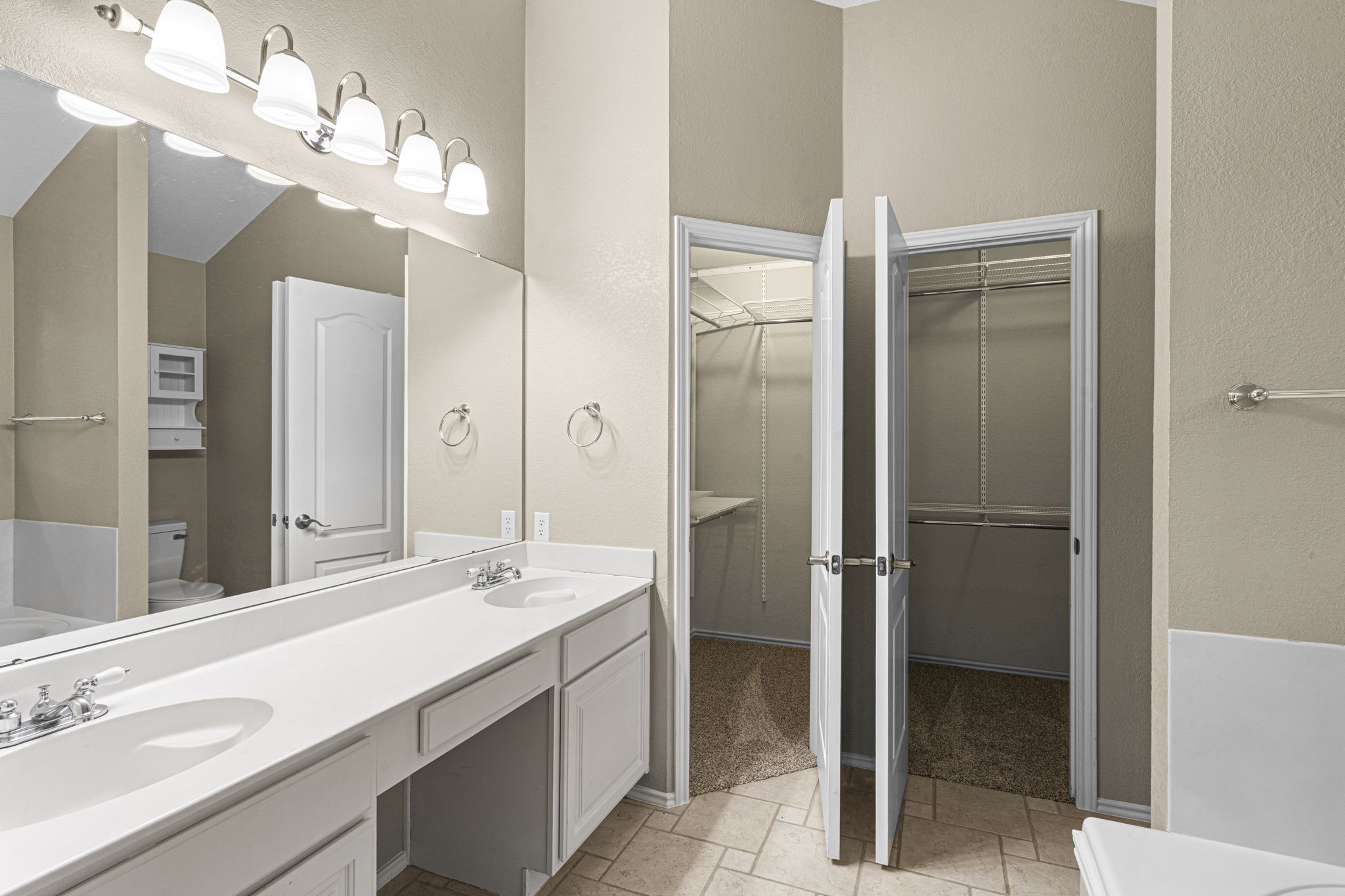 7172 Ridge Oak Road Austin, TX 78749 - Photo 31 of 40 Double vanity with ample counter space and well-appointed closet storage create a functional primary bathroom.