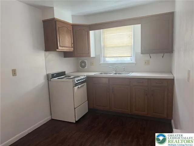 a kitchen with a sink cabinets appliances and a window