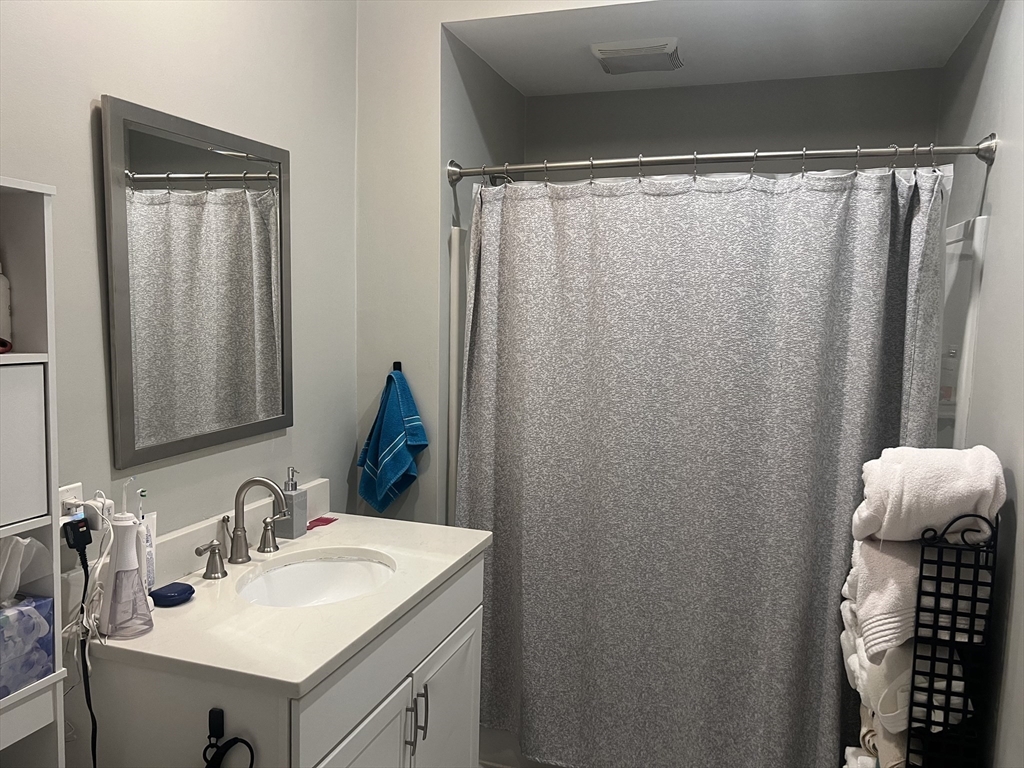 50 Humphrey Street, Unit 1 Swampscott, MA 01907 - Photo 11 of 12 a bathroom with a sink vanity and a mirror