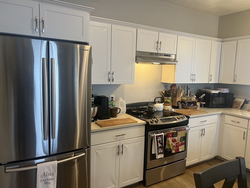 50 Humphrey Street, Unit 1 Swampscott, MA 01907 - Photo 3 of 12 a kitchen with stainless steel appliances a refrigerator stove and sink