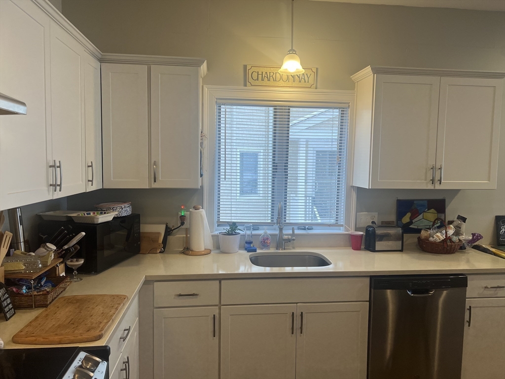 50 Humphrey Street, Unit 1 Swampscott, MA 01907 - Photo 4 of 12 a kitchen with a sink cabinets and window