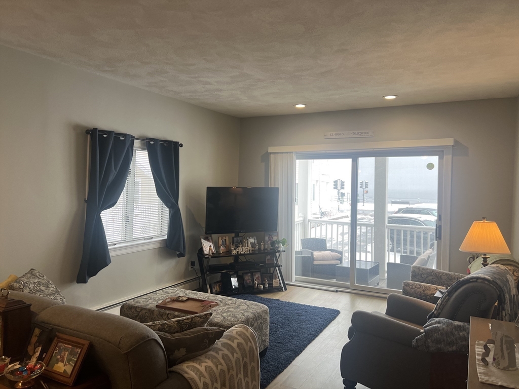 50 Humphrey Street, Unit 1 Swampscott, MA 01907 - Photo 8 of 12 a bedroom with furniture and a flat screen tv