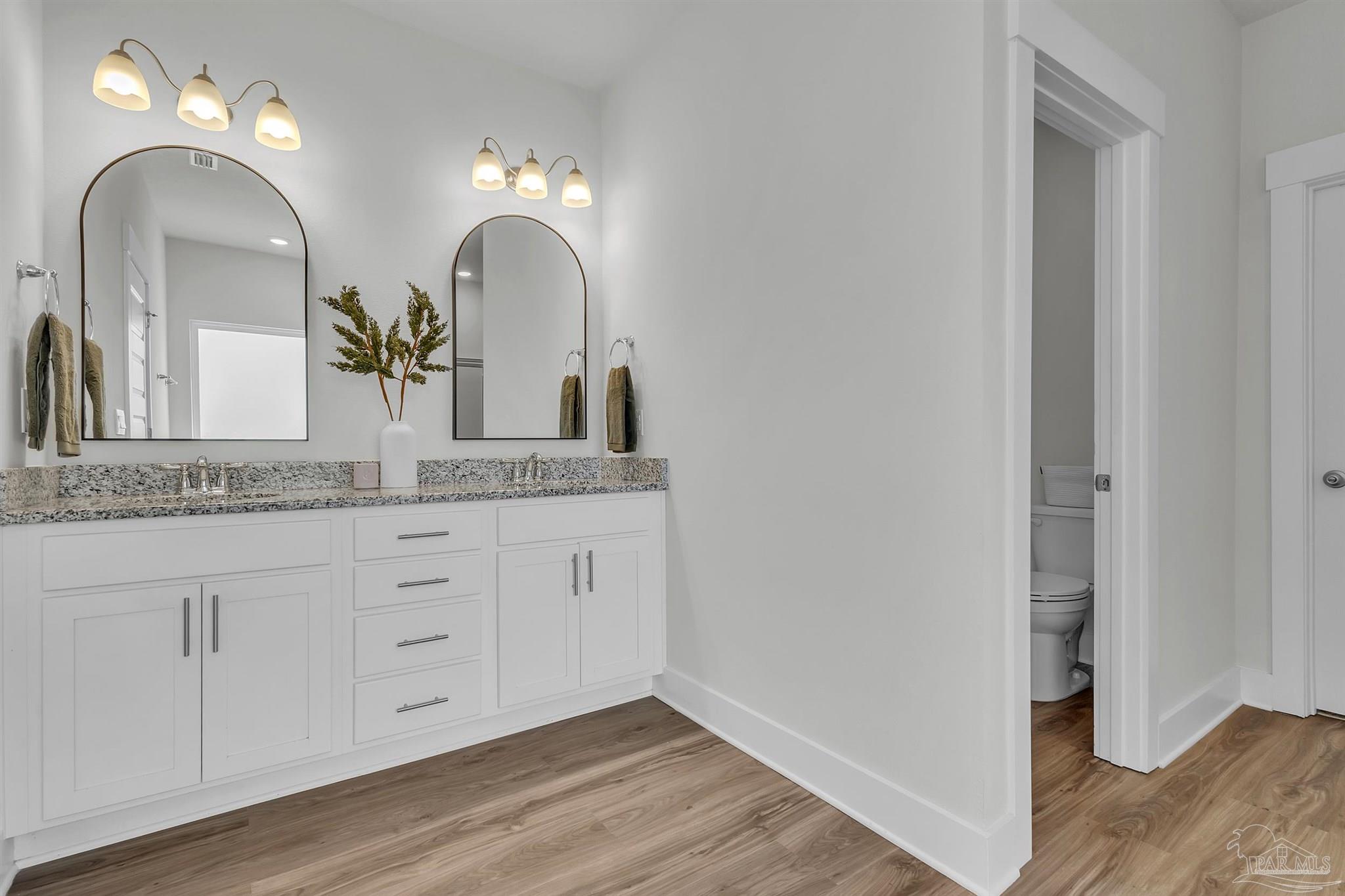 5531 Blake Lane Pace, FL 32571 - Photo 26 of 43 a bathroom with a double vanity sink and a mirror with wooden floor