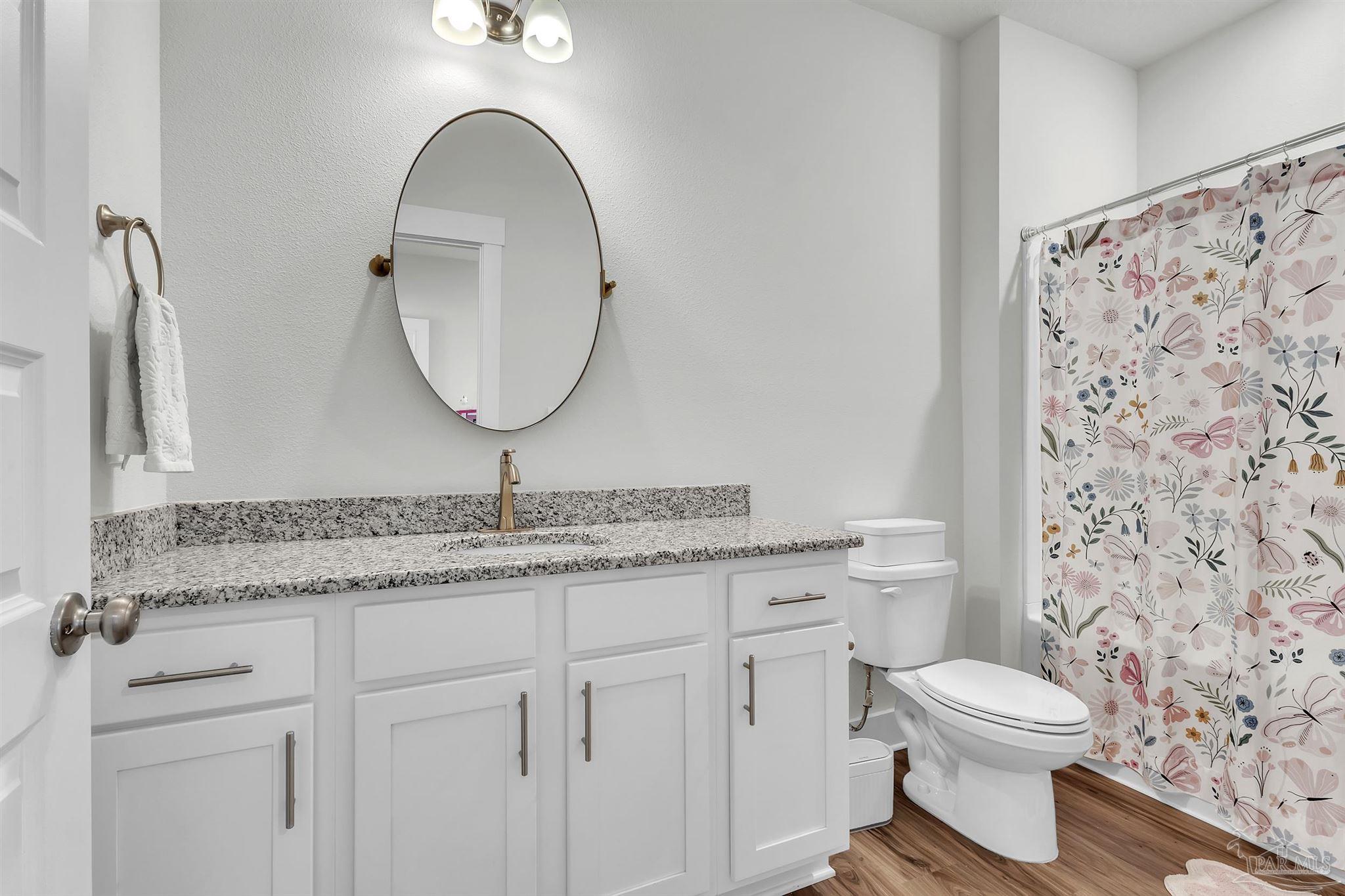 5531 Blake Lane Pace, FL 32571 - Photo 28 of 43 a bathroom with a granite countertop toilet sink and mirror