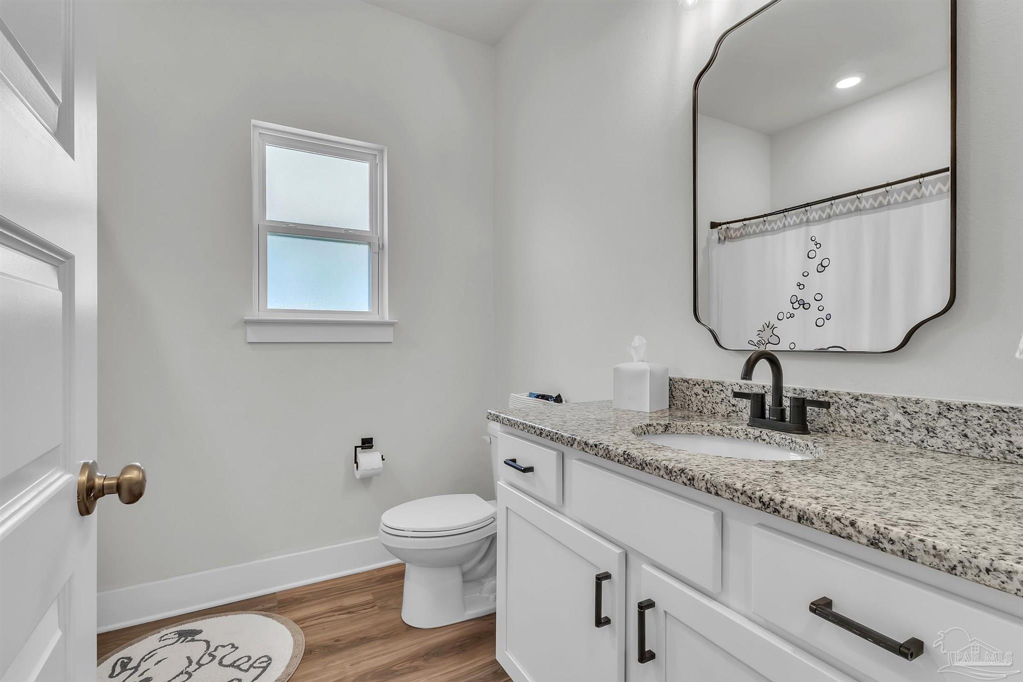 5531 Blake Lane Pace, FL 32571 - Photo 31 of 43 a bathroom with a granite countertop toilet sink and mirror