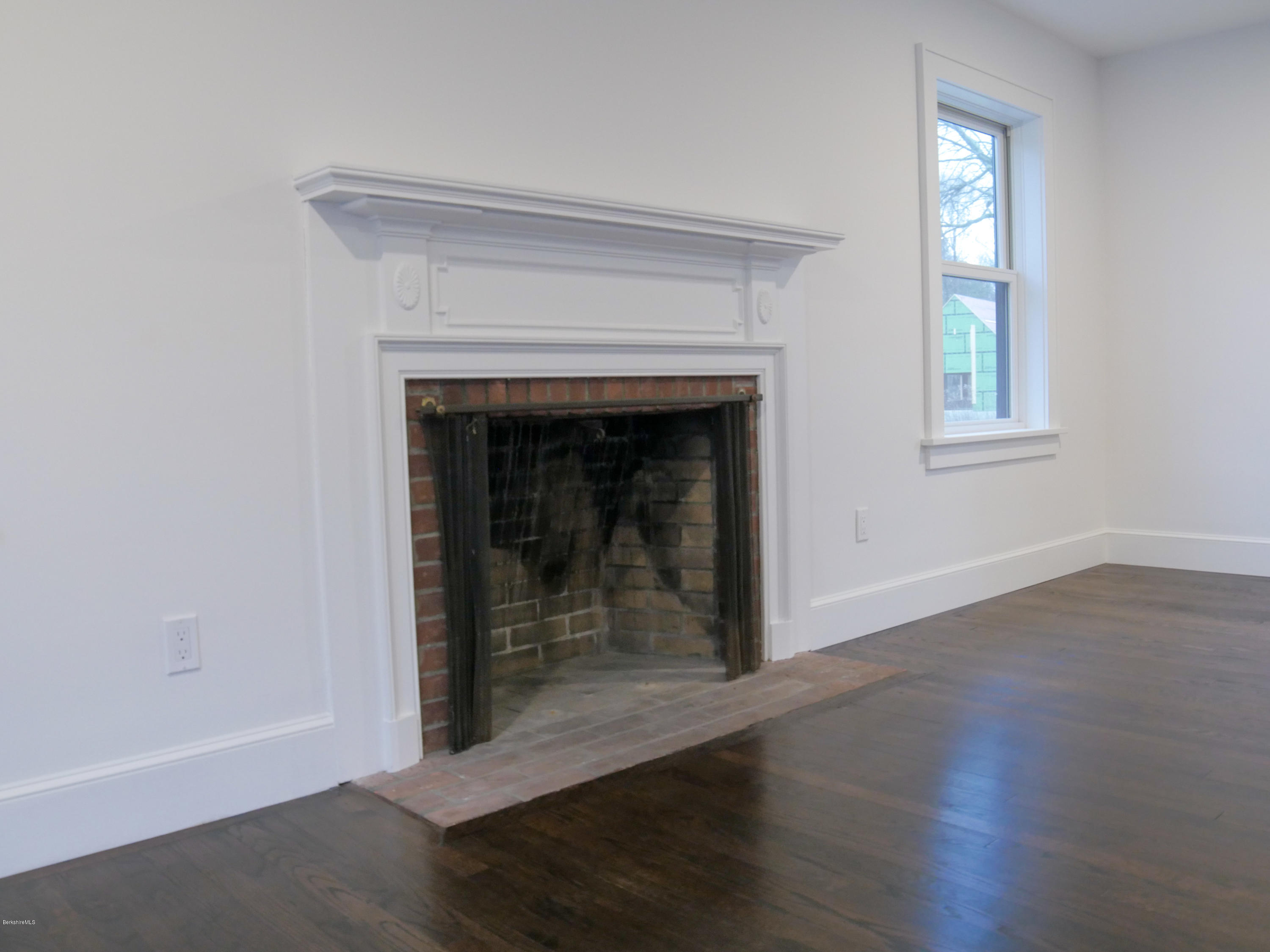 22 Prospect Hill Road Stockbridge, MA 01262 - Photo 56 of 78 an empty room with wooden floor fireplace and windows
