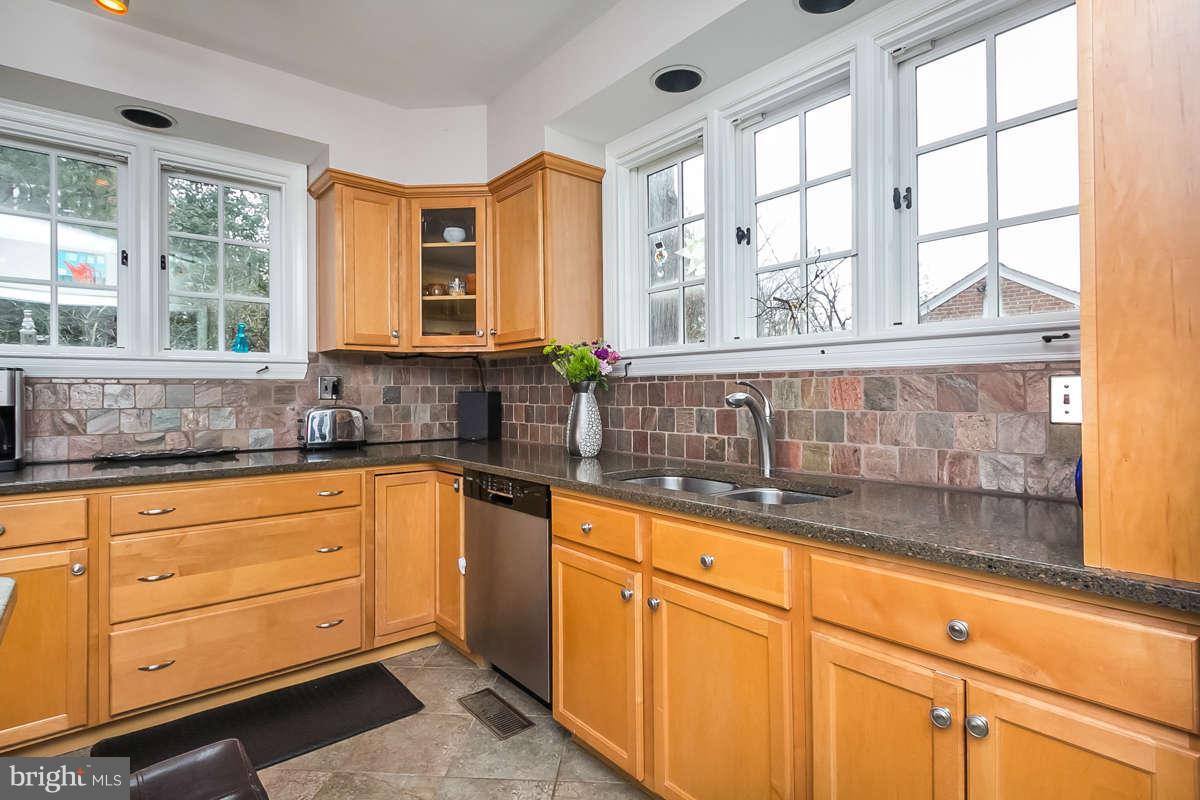 205 Longwood Road Baltimore, MD 21210 - Photo 7 of 30 a kitchen with granite countertop wooden cabinets a sink and a window