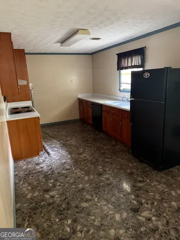 a kitchen with granite countertop a refrigerator and a stove