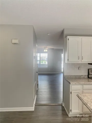 a view of hallway with wooden floor and cabinet