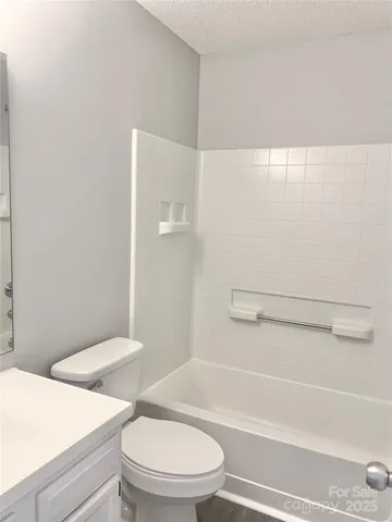 a white toilet and tub sitting next to a bathroom sink