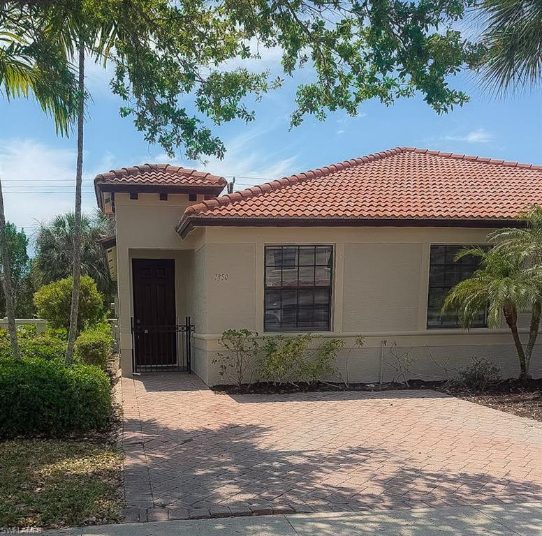 7350 Bristol Circle Naples, FL 34120 - Photo 1 of 8 a front view of a house with a garden
