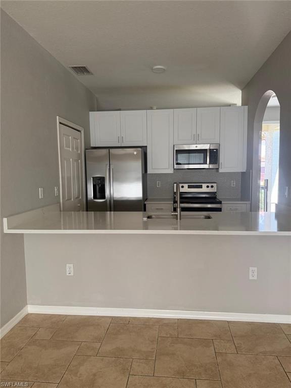 7350 Bristol Circle Naples, FL 34120 - Photo 3 of 8 a kitchen with stainless steel appliances a refrigerator sink and microwave