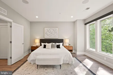 a bedroom with a bed and wooden floor