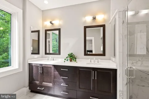 a bathroom with a sink mirror and a shower