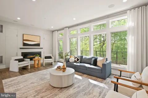 a living room with fireplace furniture and a large window