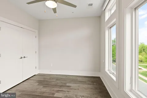 an empty room with wooden floor and windows