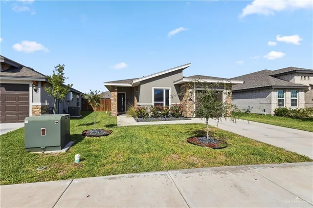 a front view of a house with garden space and patio