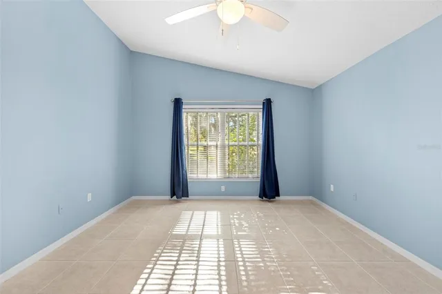 a view of a livingroom with a chandelier fan and windows