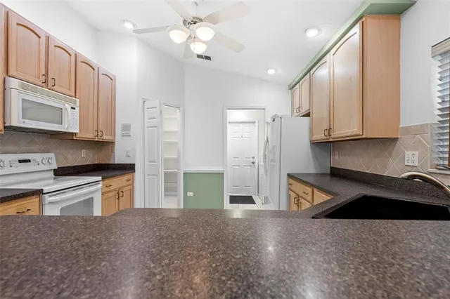 a kitchen with stainless steel appliances granite countertop a sink and a stove