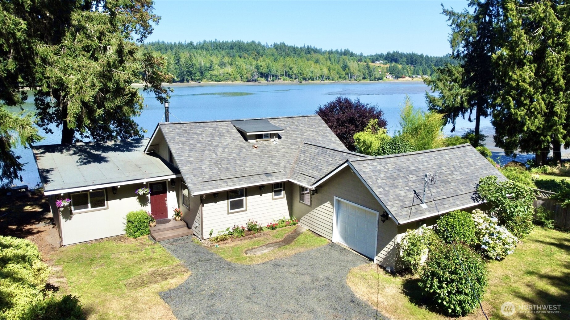 an aerial view of a house with a yard and large tree