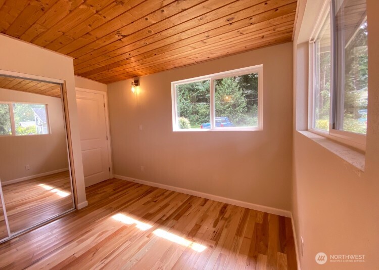 1304 Madrona Beach Road Northwest Olympia, WA 98502 - Photo 23 of 40 a view of an empty room with wooden floor and a window