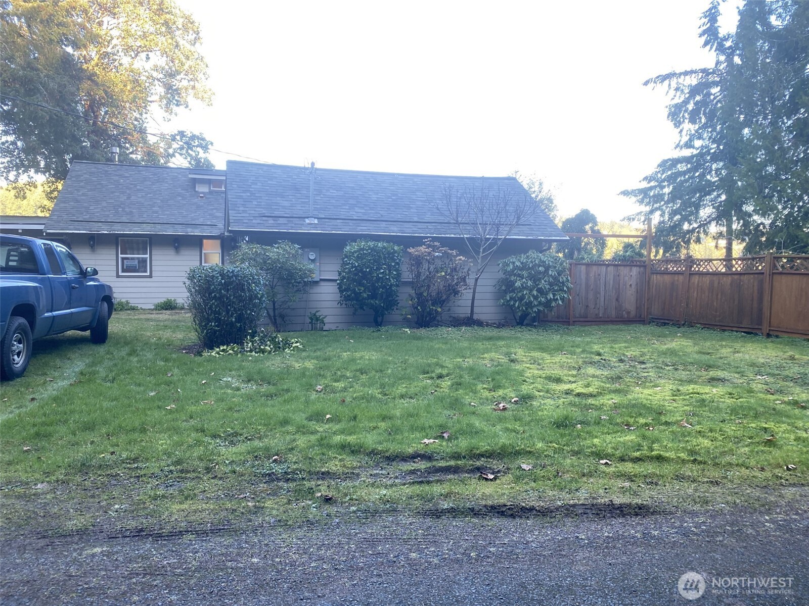 1304 Madrona Beach Road Northwest Olympia, WA 98502 - Photo 38 of 40 a view of a backyard with potted plants and wooden fence