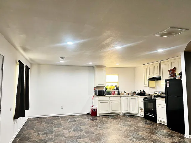 a kitchen with stainless steel appliances kitchen island granite countertop a refrigerator and cabinets