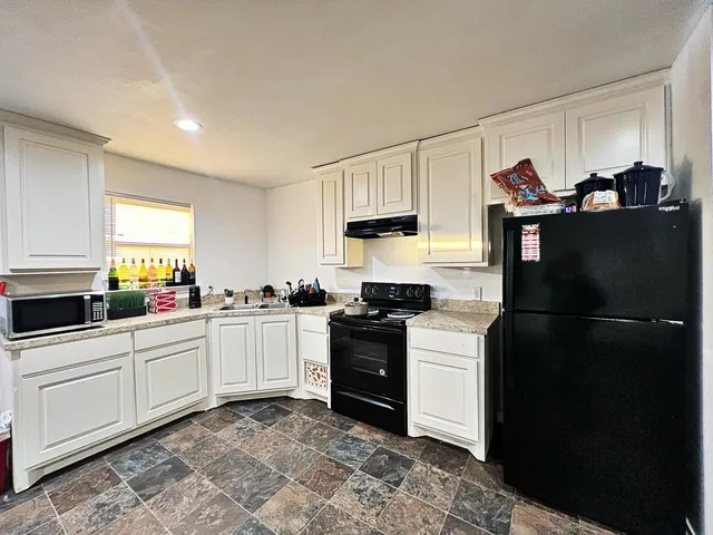 a kitchen with a refrigerator and a stove top oven