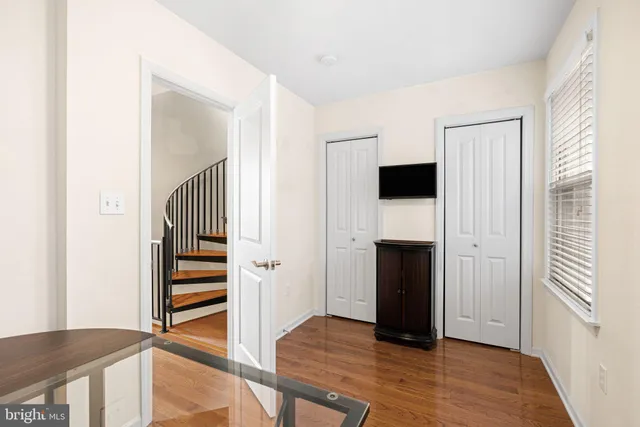 a view of a hallway with wooden floor and staircase