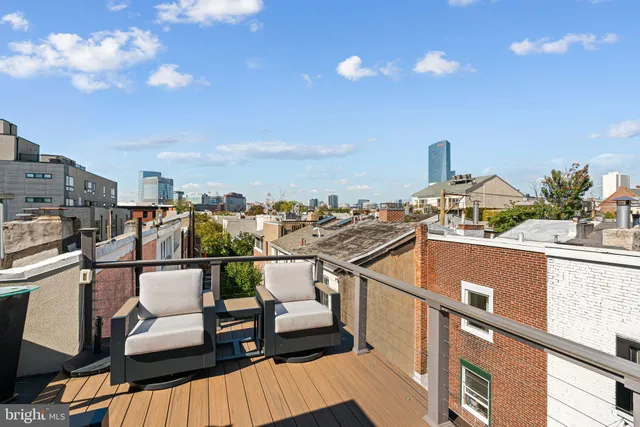 a view of a balcony with chairs and potted plants