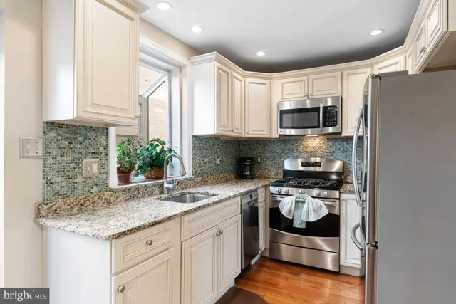 a kitchen with stainless steel appliances granite countertop a stove a sink and a microwave