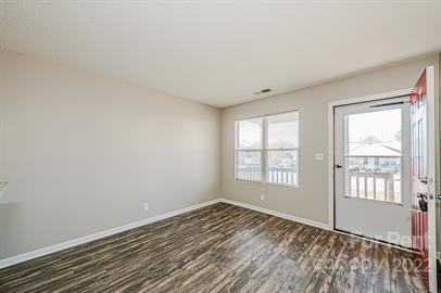 308 South Hoskins Road, Unit D Charlotte, NC 28208 - Photo 11 of 19 an empty room with wooden floor and windows