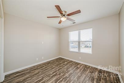 308 South Hoskins Road, Unit D Charlotte, NC 28208 - Photo 17 of 19 an empty room with wooden floor fan and windows