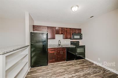 308 South Hoskins Road, Unit D Charlotte, NC 28208 - Photo 4 of 19 a kitchen with stainless steel appliances granite countertop a refrigerator and a stove top oven