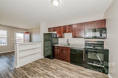 308 South Hoskins Road, Unit D Charlotte, NC 28208 - Photo 5 of 19 a kitchen with a refrigerator stove and sink