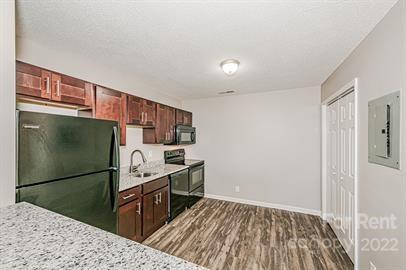 308 South Hoskins Road, Unit D Charlotte, NC 28208 - Photo 8 of 19 a kitchen with granite countertop a refrigerator and a stove top oven