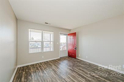 308 South Hoskins Road, Unit D Charlotte, NC 28208 - Photo 10 of 19 an empty room with wooden floor and windows