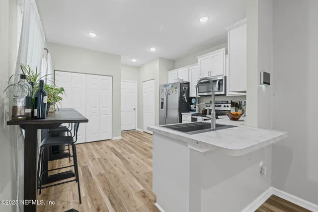 a kitchen with stainless steel appliances granite countertop a refrigerator a stove top oven a sink and dishwasher