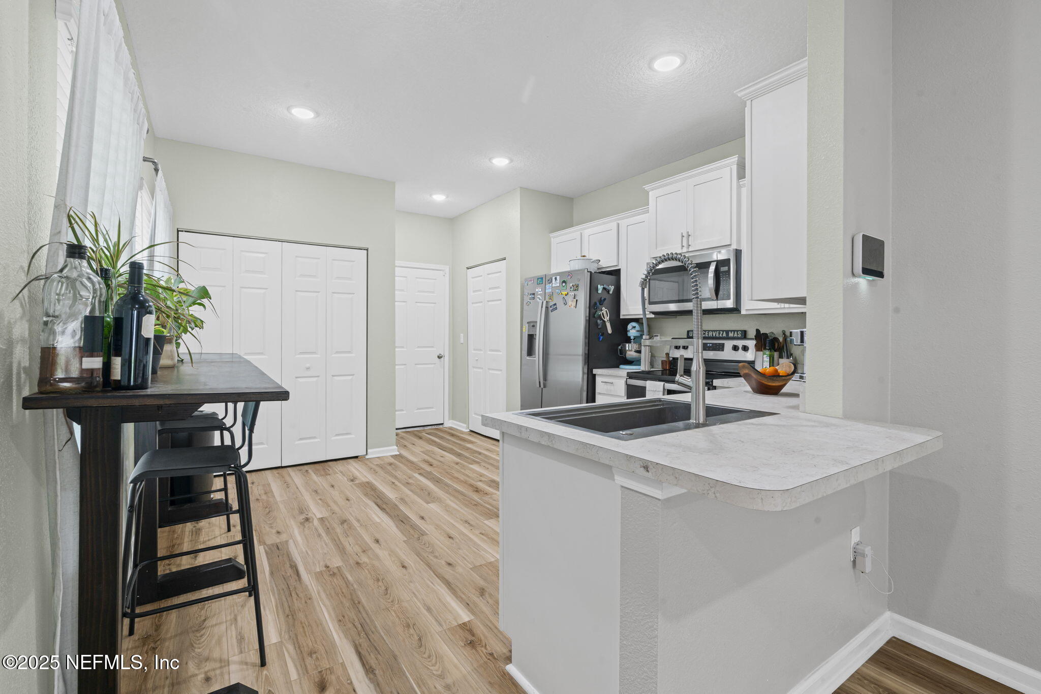 852 Capitol Parkway Jacksonville, FL 32218 - Photo 13 of 42 a kitchen with kitchen island a stove a table and chairs in it