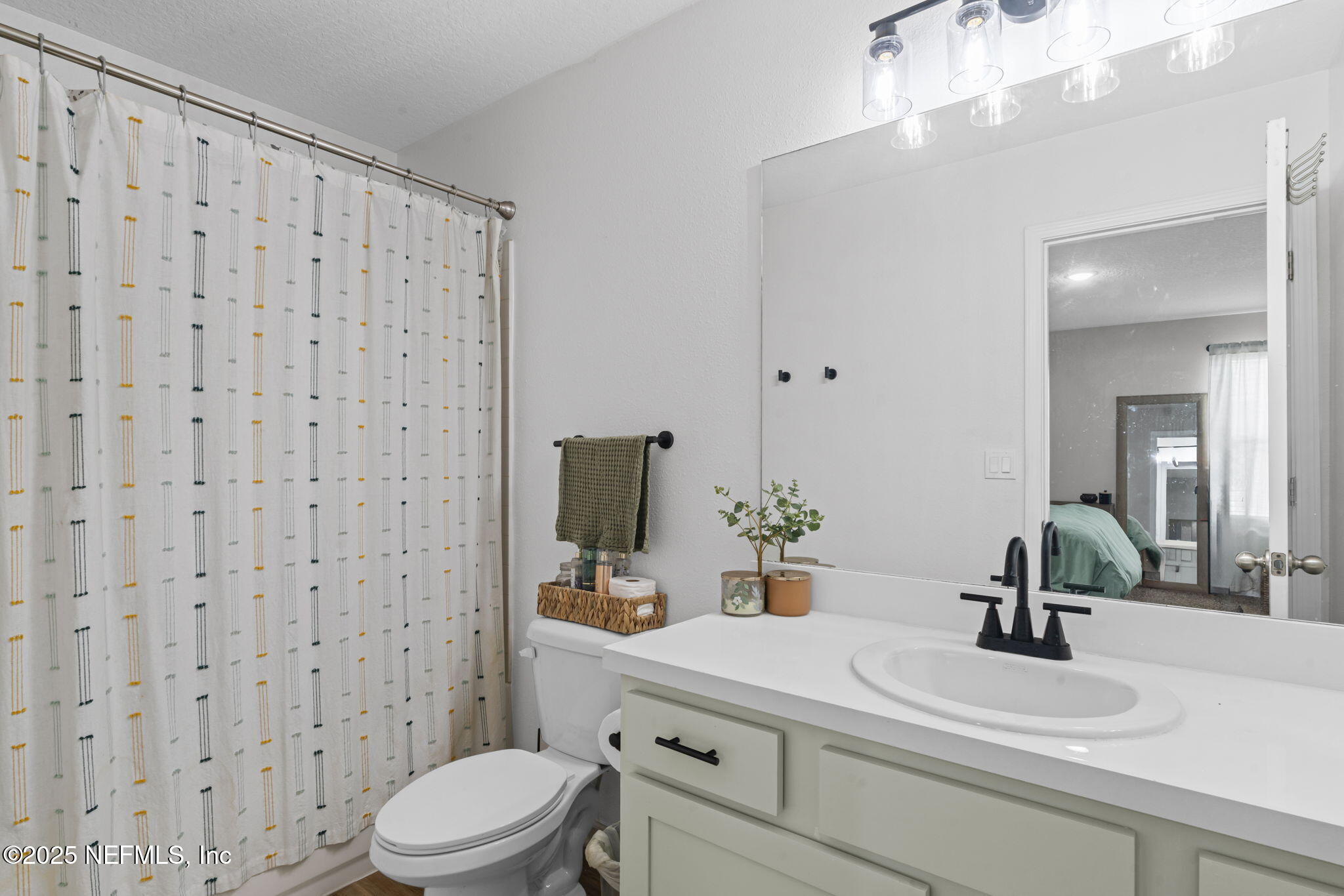 852 Capitol Parkway Jacksonville, FL 32218 - Photo 21 of 42 a bathroom with a sink a toilet a mirror and shower curtain