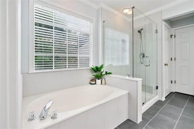 a white bath tub sitting in a bathroom next to a window