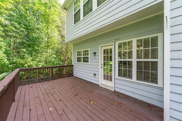 a view of deck with wooden floor and fence next to a yard