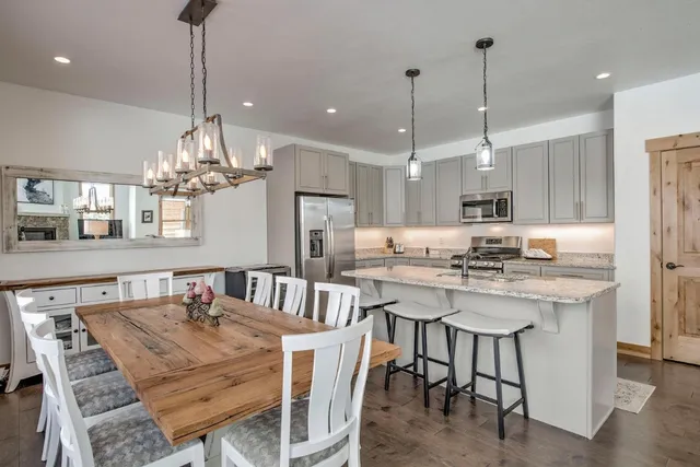 a kitchen with kitchen island a dining table chairs sink and cabinets