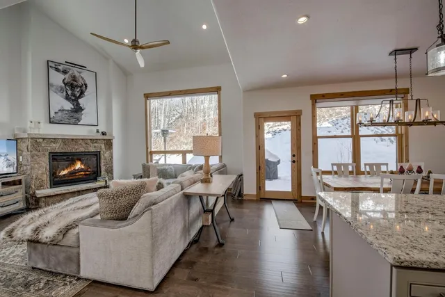 a living room with furniture a large window and a fireplace