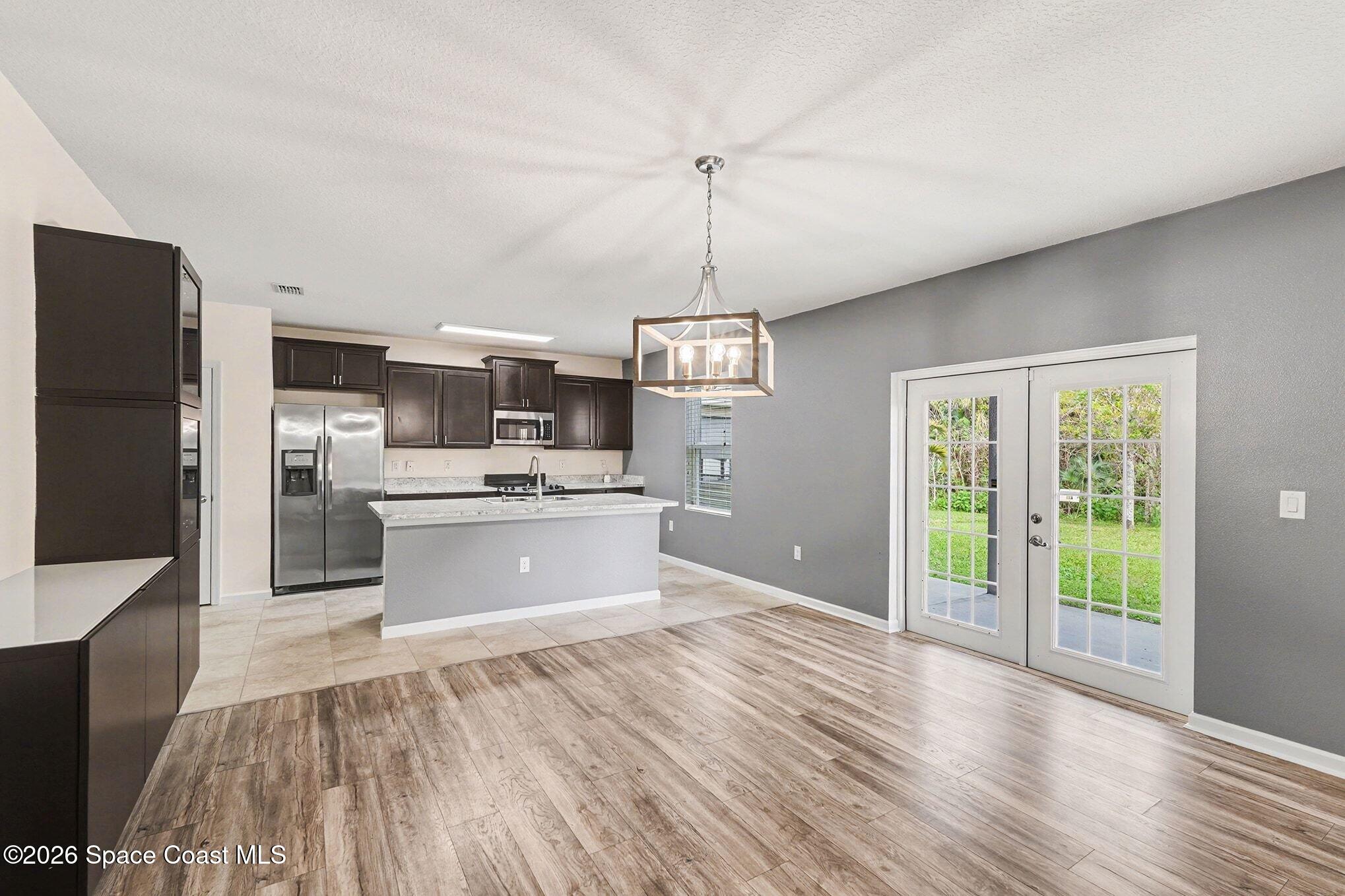 2535 Falcon Lane Mims, FL 32754 - Photo 11 of 31 a view of kitchen with granite countertop stainless steel appliances cabinets a sink and a wooden floor