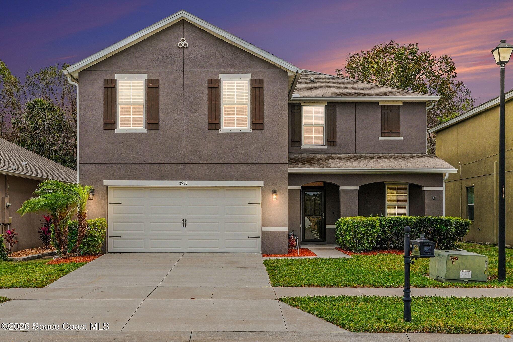 2535 Falcon Lane Mims, FL 32754 - Photo 2 of 31 a front view of a house with a yard and garage